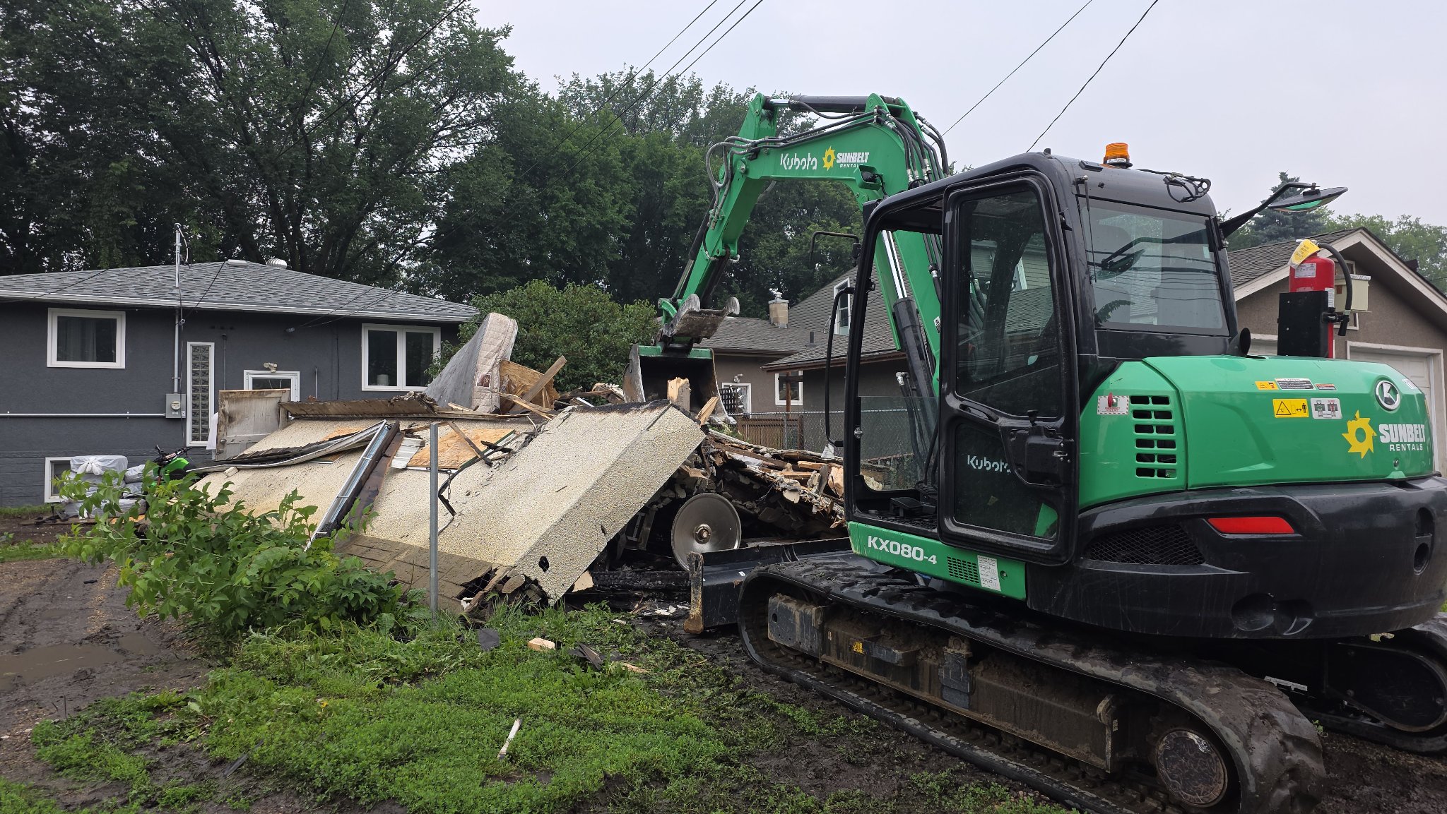 Excavator demolishing a house
